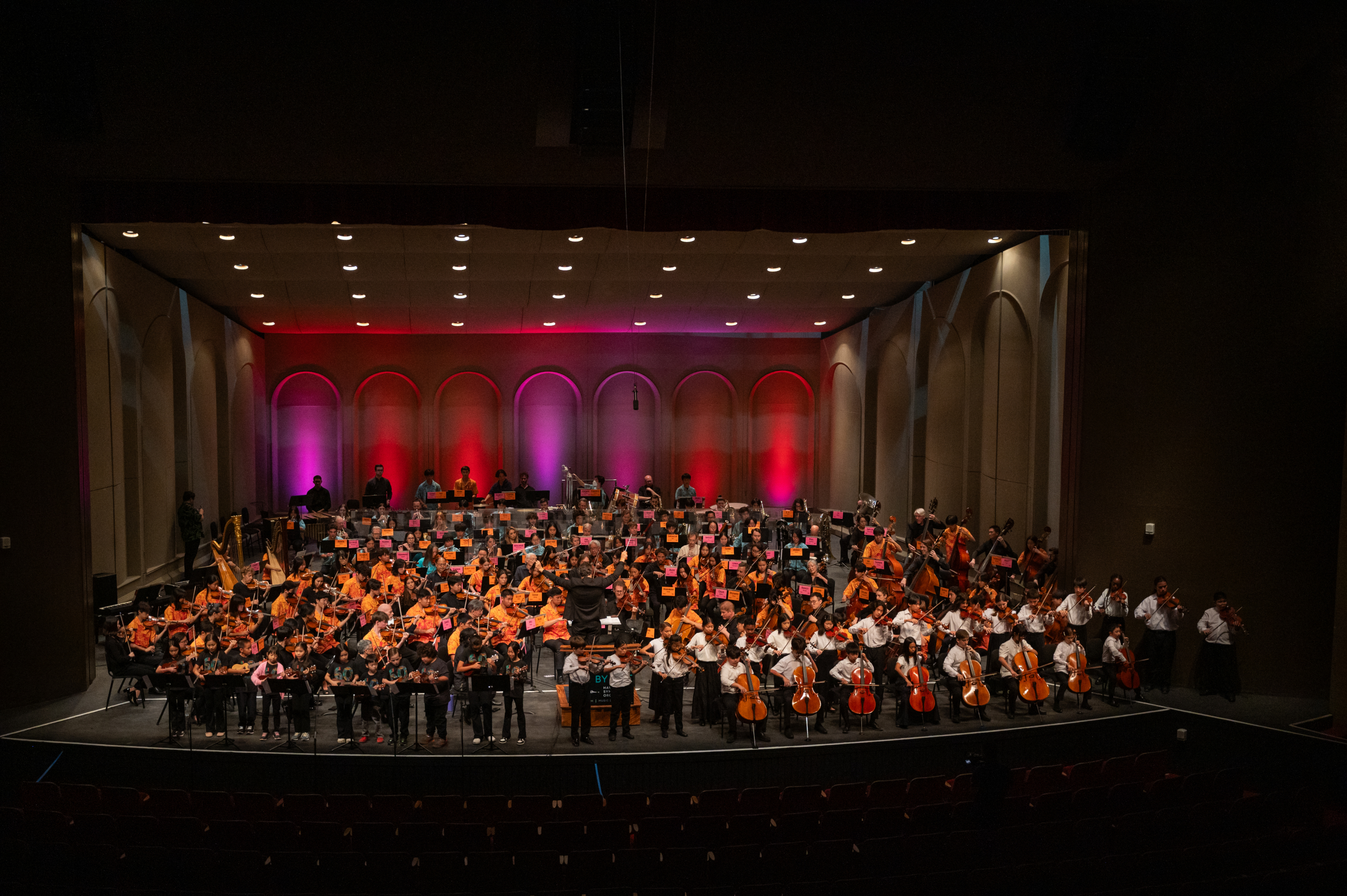Imagen de estudiantes haciendo música en una sala de conciertos